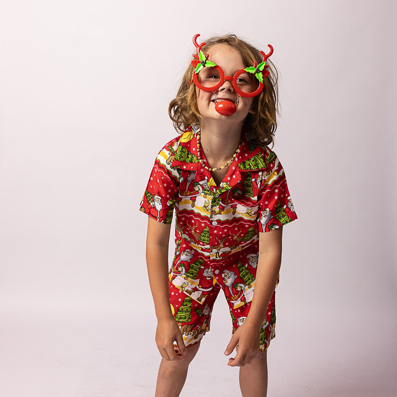 Red Happy Santa Kids Shirt with festive Christmas print, paired with matching red and white Christmas pajamas. | Tropicool Clothing