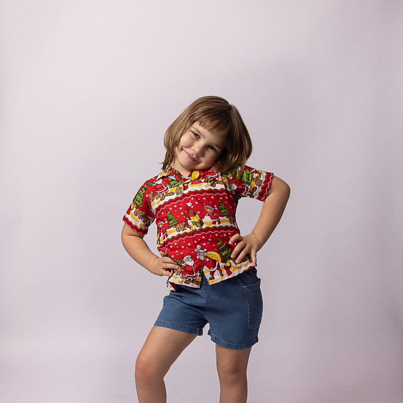 Happy Santa red kids shirt with festive print, paired with classic blue denim shorts. Tropical holiday style. | Tropicool Clothing