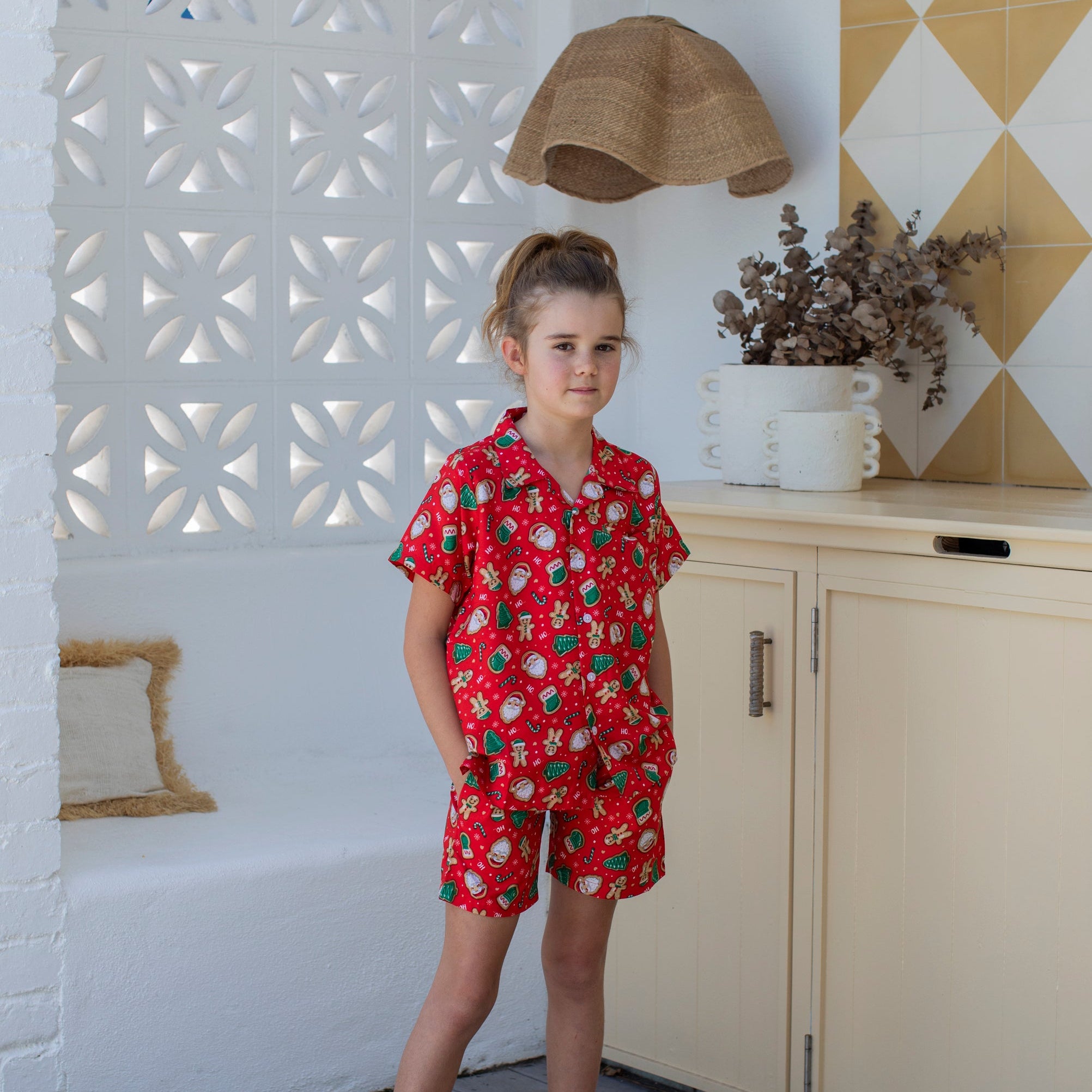 Gingerbread Jest Christmas kids shirt with festive gingerbread man pattern and holiday colors, short sleeves. | Tropicool Clothing