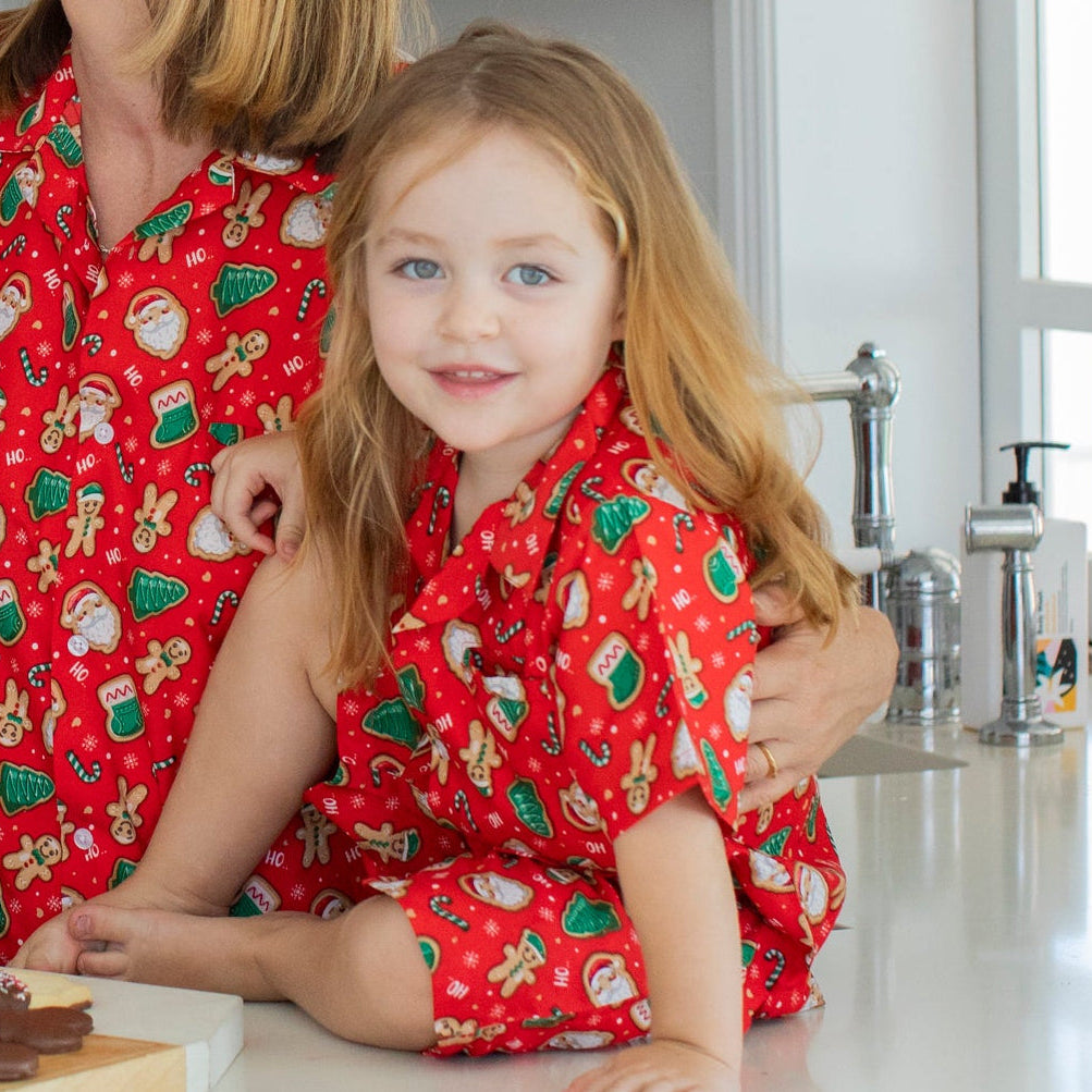 Red Christmas kids shirt featuring gingerbread and festive patterns, matching family holiday apparel. | Tropicool Clothing