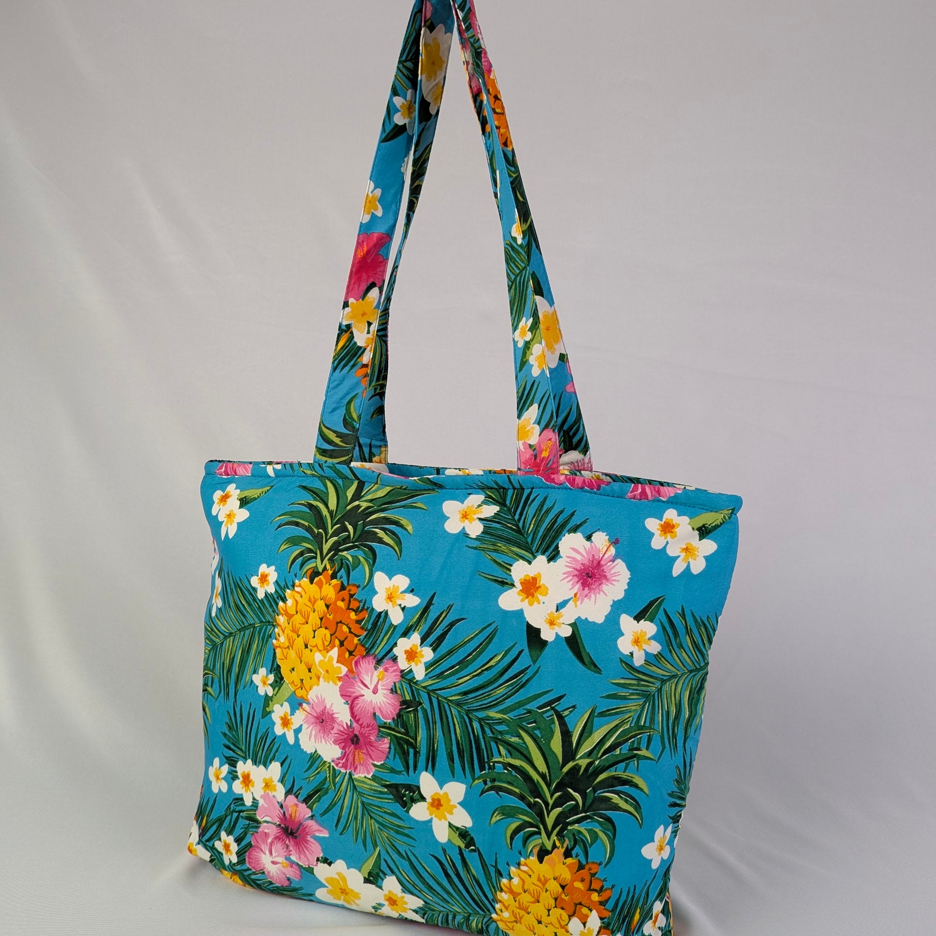 Blue Tropicool Tote Bag with yellow pineapples, green leaves, and pink-white tropical flowers print. | Tropicool Clothing