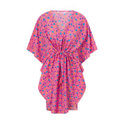 A pink kaftan with a retro vibe, featuring a geometric pattern with blue and red shapes.