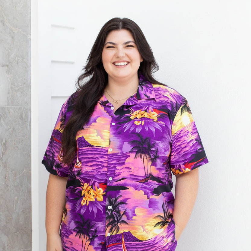 Plus-size model wearing a purple tropical sunset print outfit
