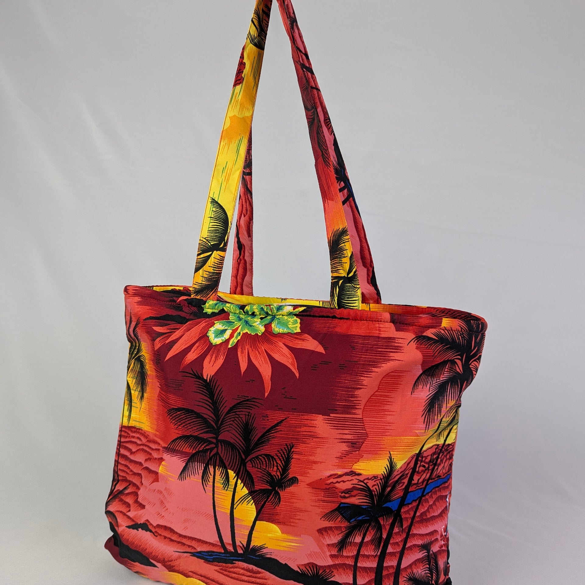 Tropicool Tote Bag with red, yellow, and black palm tree pattern on a minimalist background; tropical accessory. | Tropicool Clothing