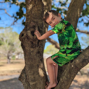 Sunset Green Kids Shirt features a vibrant tropical pattern, short sleeves, and festive summer colors. | Tropicool Clothing