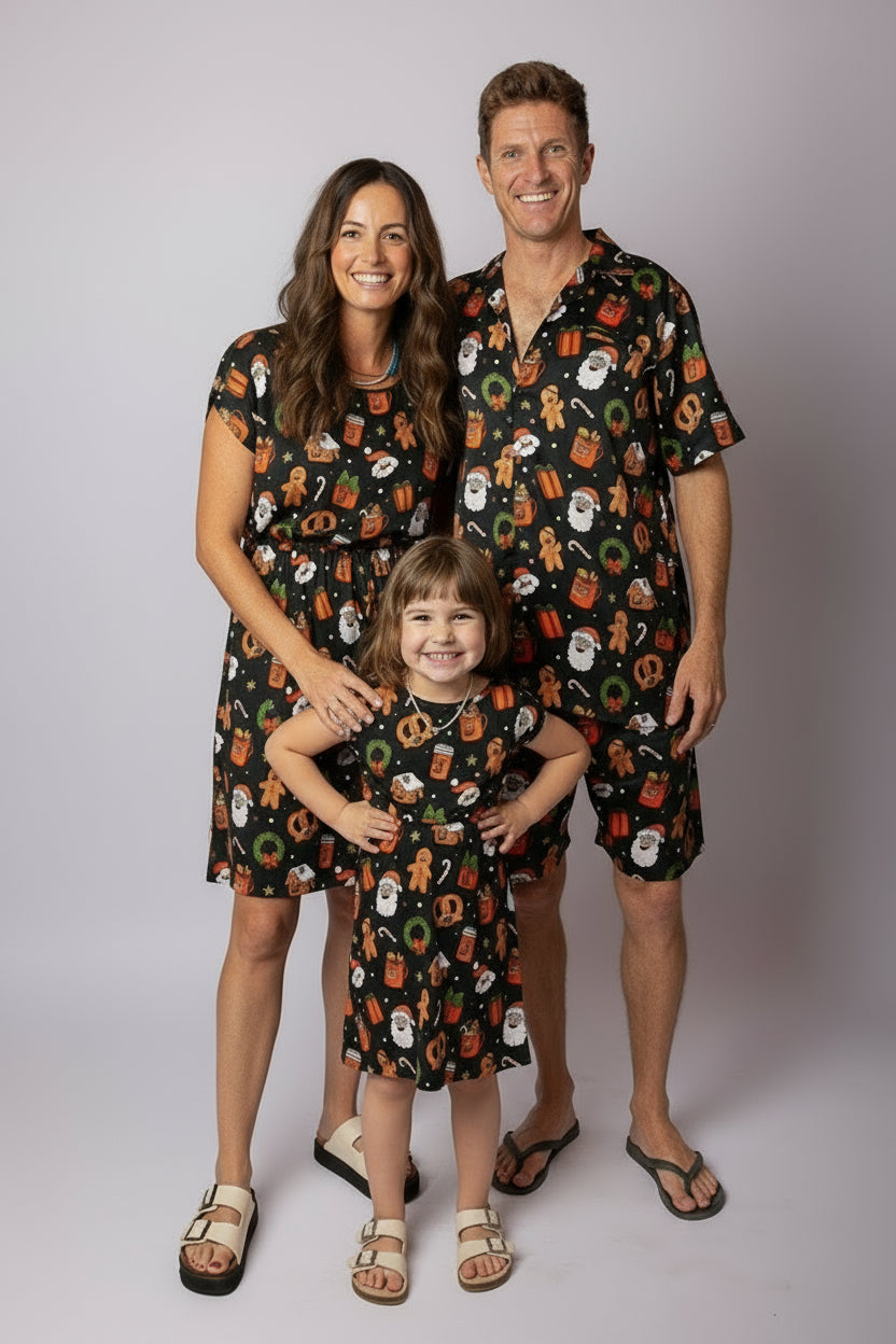 Family in matching Tropicool Jingleverse Christmas outfits – shirts and dresses with festive prints, ideal for Holiday celebrations.