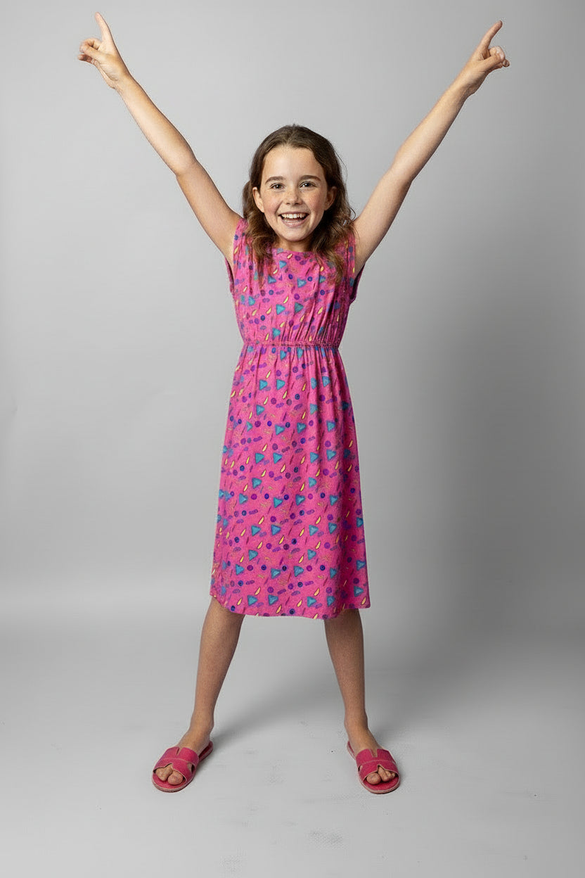 Young girl wearing a pink dress with retro vibe pattern on a white background